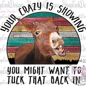 May include: A vintage-style graphic with a donkey's head peeking out from behind a red, white, and blue striped circle. The text "YOUR CRAZY IS SHOWING YOU MIGHT WANT TO TUCK THAT BACK IN" is written around the circle.
