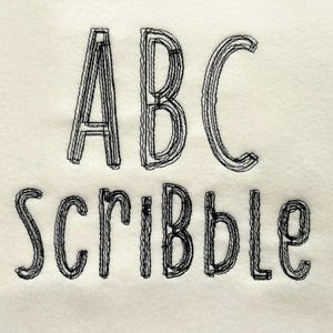 May include: Off-white fabric featuring black embroidered text. The word "ABC" is above "Scribble" in a layered, textured font. The letters are thick and outlined, giving a handmade, artistic appearance.
