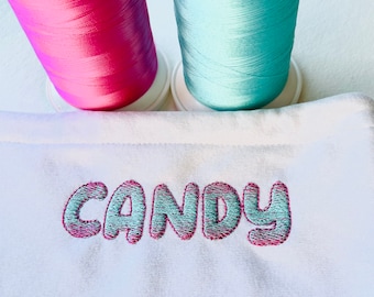 May include: White fabric with the word "CANDY" embroidered in pink and blue thread.