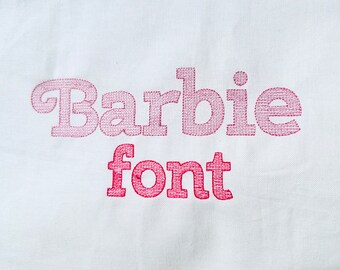 Pode incluir: Um tecido branco com as palavras "Barbie font" bordadas em fio rosa.
