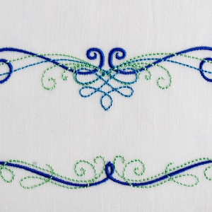 May include: An embroidered design featuring two symmetrical swirls with a central knot, in blue and green thread.