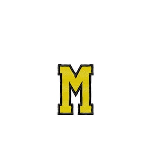 May include: An embroidered letter M design featuring a yellow fill with a thick black outline. The design measures 1.94 inches by 2.76 inches. The color palette includes Harvest Gold and Black, with a total stitch count of 7,179 stitches.