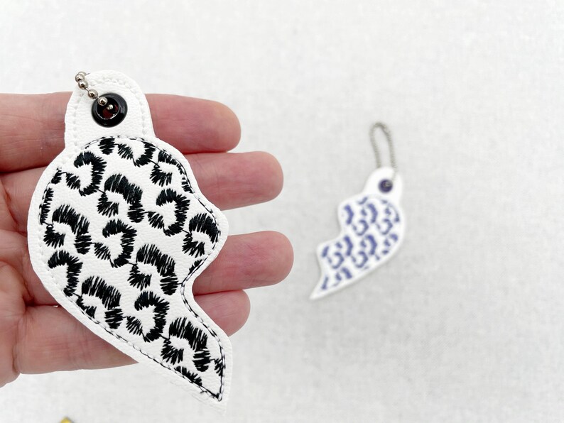Product detail view of Leopard print Split Heart Eyelet and Key Fob Snap Tab keychain in the hoop machine embroidery designs ITH Valentines Instant Download By Fonts Heaven Embroidery Format PES HUS DST JEF EXP VP3 XXX EXP