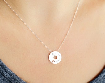 May include: A silver necklace with a round pendant featuring a small airplane cutout and a dotted circle design.