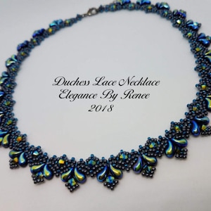 May include: A blue and green beaded necklace with a teardrop design. The necklace is labelled "Duchess Lace Necklace Elegance By Renee 2018".