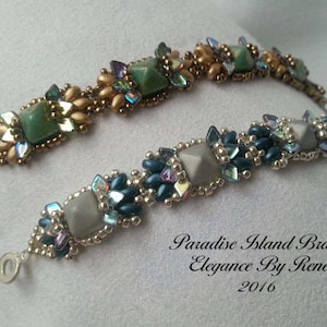 May include: Two beaded bracelets with green and grey square beads, gold and silver accents, and a silver clasp. The bracelets are labelled "Paradise Island Bracelet Elegance By Renee 2016".