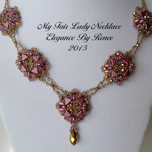 Puede incluir: Un collar de cadena dorada con cuatro colgantes de cuentas rosadas y doradas. El collar se llama "My Fair Lady Necklace Elegance By Renee 2015".