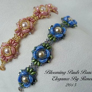 Pode incluir: Duas pulseiras de contas com desenhos de flores. Uma pulseira é rosa e dourada, a outra é azul e verde. As pulseiras estão sobre um fundo branco. Blooming Buds Bracelet Elegance By Renee 2015.