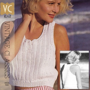 May include: A white crochet tank top with a button fastening. The tank top is sleeveless and has a scoop neck. The model is wearing the tank top with a red and white striped skirt. The image also includes a close-up of the back of the tank top.