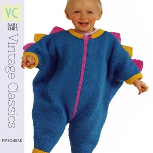 May include: A blue knitted baby jumpsuit with a dinosaur design. The jumpsuit features a pink zipper, yellow and pink accents, and a dinosaur fin design on the back. The text "Vintage Classics" and "PIPSQUEAK" are visible.