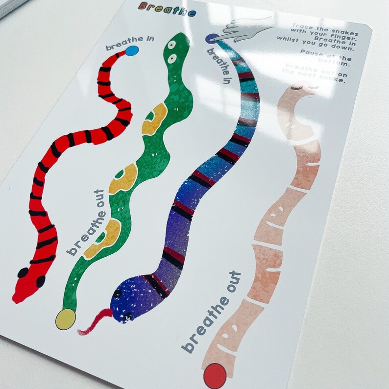 Puede incluir: Una tarjeta blanca con tres serpientes de colores sobre ella. Las serpientes est&aacute;n etiquetadas con "inspirar" y "expirar". La tarjeta est&aacute; dise&ntilde;ada para ayudar con los ejercicios de respiraci&oacute;n.