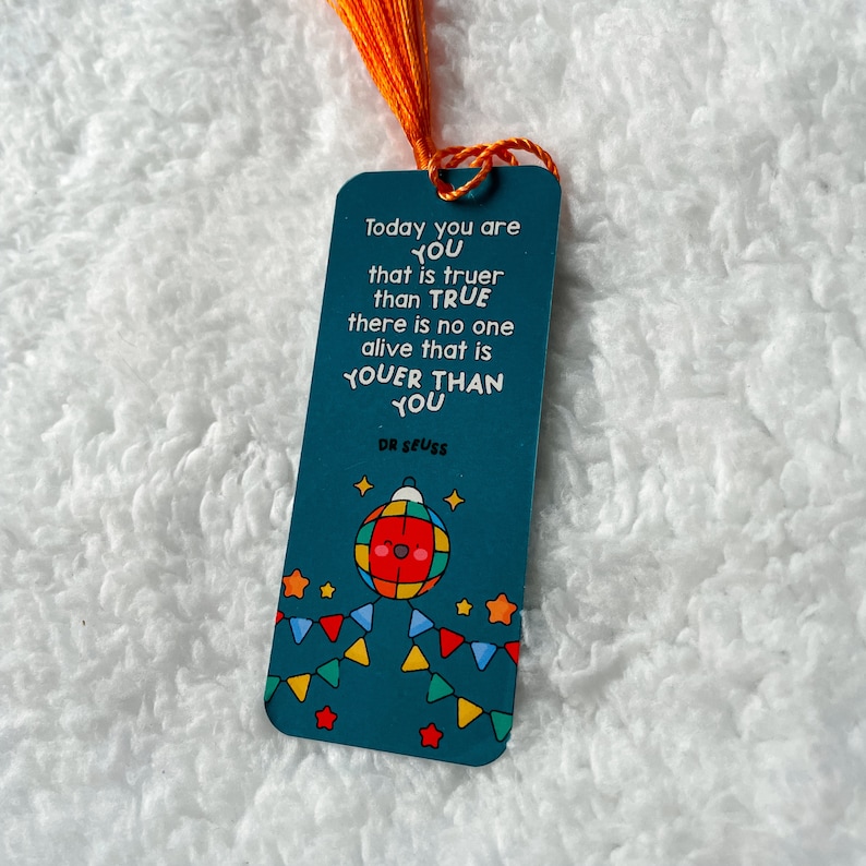 May include: A blue bookmark with a colourful illustration of a disco ball and the text "Today you are YOU that is truer than TRUE there is no one alive that is YOUER THAN YOU DR SEUSS"