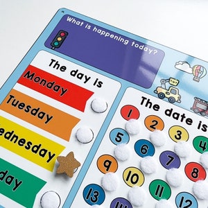 K&ouml;nnte beinhalten: Ein blaues und wei&szlig;es Trockenl&ouml;schboard mit einem bunten Kalender und Datumsanzeige. Das Board hat die Frage "Was passiert heute?" und einen Bereich f&uuml;r den Wochentag. Das Board hat einen Bereich f&uuml;r das Datum mit den Zahlen 1 bis 13. Das Board hat einen Bereich f&uuml;r den Wochentag mit den Tagen Montag, Dienstag, Mittwoch und Donnerstag. Das Board hat einen Bereich f&uuml;r das Datum mit den Zahlen 1 bis 13.