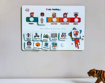 May include: A white board with a colorful chart showing different emotions and corresponding coping strategies. The chart includes images of people with different facial expressions, such as happy, worried, frustrated, and angry. Below the chart are several colorful squares with images and text, such as "Jump or dance", "Fidget toy", "Outside", "Reading", "Talk about it", "Hug", "Deep breaths", "Quiet space", "Coloring", and "Count".