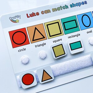 May include: A colourful educational toy with different shapes, including a circle, triangle, square, rectangle, and oval. The toy is labelled "Luke can match shapes" and features the word "Craftily" with a rainbow star.