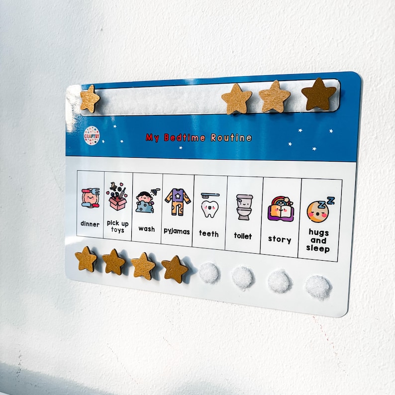 May include: A blue and white bedtime routine chart with the text "My Bedtime Routine". The chart includes illustrated icons for dinner, toys, washing, pajamas, teeth, toilet, story, and sleep. Wooden star magnets are included.