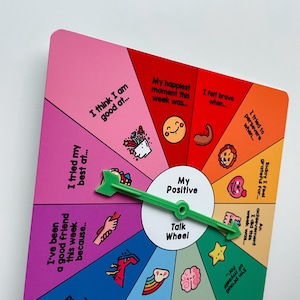 May include: A colorful paper wheel with a green arrow pointer. The wheel is divided into 10 sections, each with a different prompt for positive reflection. The prompts include "I think I am good at...", "I tried my best at...", "I've been a good friend this week because...", "My happiest moment this week was...", "I felt brave when...", "I tried to persevere when...", "Today I feel grateful for...", "An achievement I did this week was...", "I'm proud of myself for...", and "My Positive Talk Wheel".