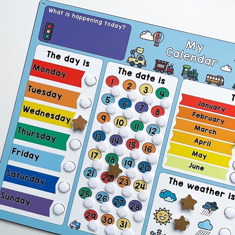 K&ouml;nnte beinhalten: Ein farbenfroher Trockenl&ouml;schkalender mit blauem Hintergrund und wei&szlig;en Kreisen f&uuml;r jeden Tag des Monats. Der Kalender enth&auml;lt einen Bereich f&uuml;r den Wochentag, das Datum und den Monat. Es gibt auch Bereiche f&uuml;r "Was passiert heute?" und "Das Wetter ist."