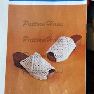May include: A pair of white crocheted sandals with wooden soles. The sandals have a woven pattern and are open-toed.