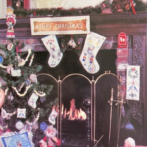 May include: A Christmas-themed needlepoint and cross stitch pattern book with a festive image of a fireplace, stockings, and a Christmas tree. The book cover features the title "Sugarplums" and the text "charted designs for needlepoint and cross stitch by Marsha McKerr".