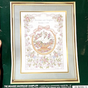 Può includere: Kit di punto croce contato Elsa Williams incorniciato, con un design di sampler di matrimonio con perline. L'opera d'arte include colombe, rose e il testo "Stretchen and Stephen, October 3 1994". Dimensioni finite: 30cm x 41cm, cornice: 41cm x 51cm.
