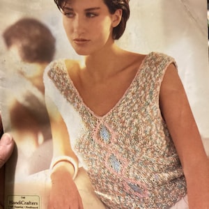 May include: A magazine cover featuring a woman wearing a knitted V-neck top with a diamond pattern in pink and blue. The magazine title is "Piccolo" and "Brunswick" is printed in blue. The HandiCrafters logo is visible.