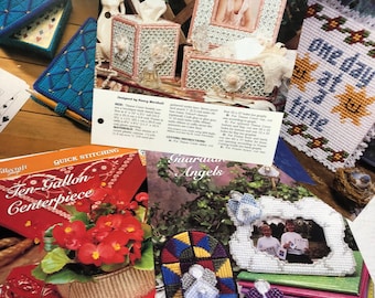 May include: A collection of plastic canvas craft patterns featuring a variety of designs, including a ten-gallon centerpiece, a ribbon confection, guardian angels, and a one-day-at-a-time design. The patterns are printed on paper with instructions and materials lists.