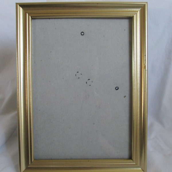 Gold plastic frame, 5" x 7" photo, 8.25" x 6.25" frame, wearing of the paint/distressed in some high areas, free standing or wall hanging