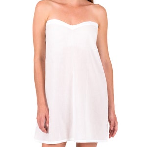 May include: A white strapless slip dress with a sweetheart neckline. The dress is made of a lightweight, flowy fabric.