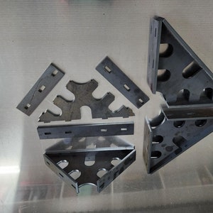 May include: A set of metal corner brackets for woodworking projects. The brackets are made of steel and have a variety of sizes and shapes. They are designed to be used in conjunction with other woodworking tools and materials.