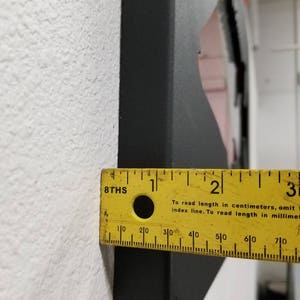Puede incluir: Una regla amarilla con marcas negras y el texto "8THS" y "Para leer la longitud en cent&iacute;metros, omita el cero final de la l&iacute;nea de &iacute;ndice. Para leer la longitud en mil&iacute;metros, incluya" impreso en ella.