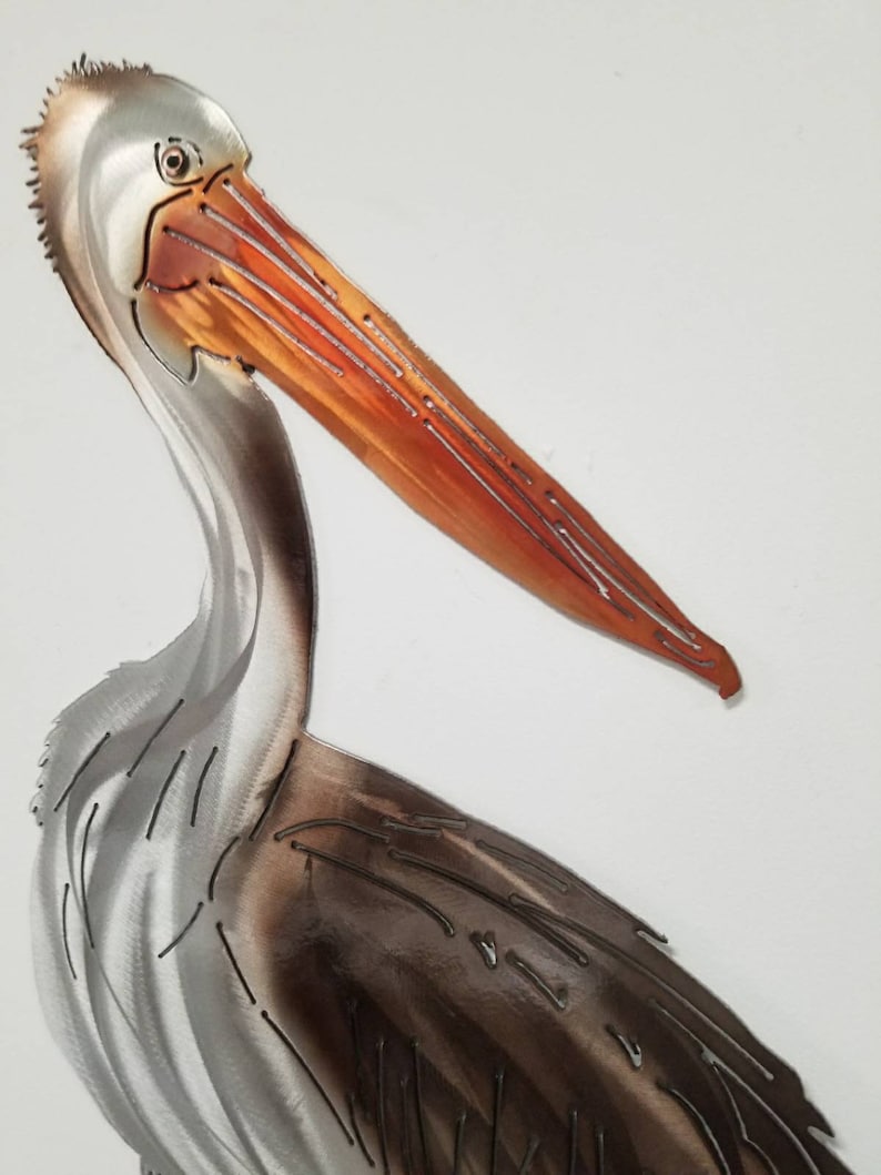 Puede incluir: Una escultura de metal de un pel&iacute;cano con un acabado marr&oacute;n y plateado. El pico del pel&iacute;cano es naranja y tiene un dise&ntilde;o detallado.