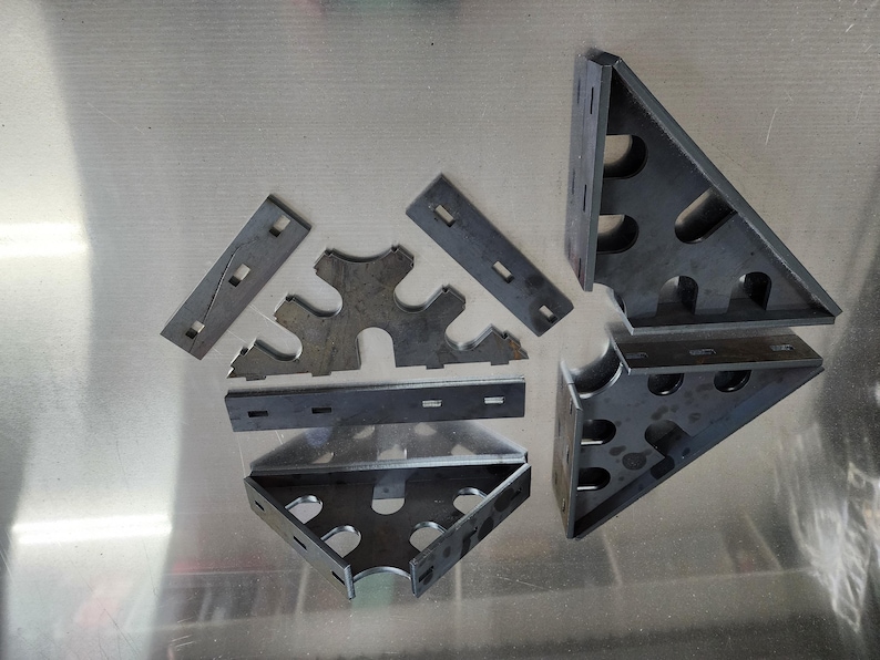 May include: A set of metal corner brackets for woodworking projects. The brackets are made of steel and have a variety of sizes and shapes. They are designed to be used in conjunction with other woodworking tools and materials.