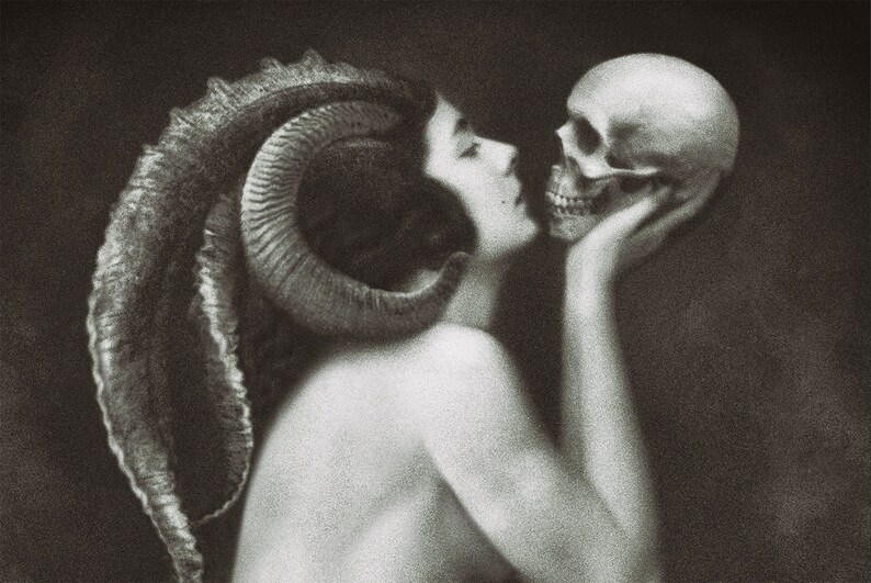 May include: A black and white artistic print featuring a profile view of a figure with large, curved ram horns extending from the head. The figure is shown from the shoulders up, leaning forward to touch a human skull held in their hand.