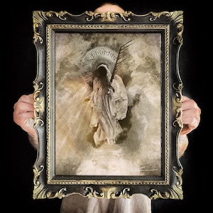 Pode incluir: Uma impressão artística emoldurada apresentando uma figura encapuzada com túnica branca segurando uma espada, contra um fundo de nuvens e raios de luz. A figura tem um halo circular intrincado. A moldura é preta com detalhes dourados ornamentados.