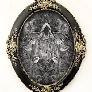 May include: An oval wall art piece featuring a black and white intricate illustration of a hooded figure with wings and multiple hands, each displaying an eye on the palm. The artwork is encased in a black frame with ornate gold-colored metal accents.