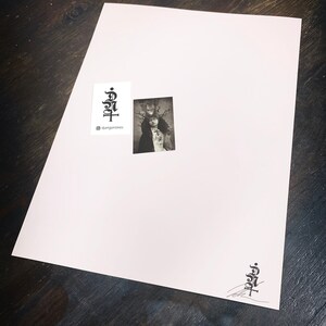 Puede incluir: Una impresi&oacute;n rectangular blanca que presenta una peque&ntilde;a fotograf&iacute;a en blanco y negro de una persona con una corona de espinas. La impresi&oacute;n incluye un logotipo negro con el texto djangonokes y un logotipo a juego con una firma.