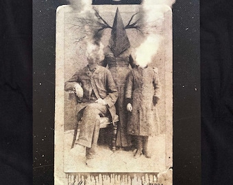 May include: A vintage black and white photograph of three people, with a pointed hat covering the head of the person in the middle. The photo is faded and has a crescent moon in the top center.