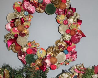 May include: A festive Christmas wreath with a matching garland. The wreath is adorned with fabric balls, velvet circles, and red ribbons. The garland features fabric strips, small red tree cutouts, and red ornaments. The color palette includes shades of green, pink, and red.