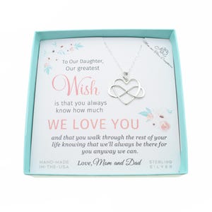 May include: A silver infinity heart necklace in a gift box with a message to a daughter. The message reads "To Our Daughter, Our greatest Wish is that you always know how much WE LOVE YOU and that you walk through the rest of your life knowing that we'll always be there for you anyway we can. Love, Mom and Dad. Sterling Silver."
