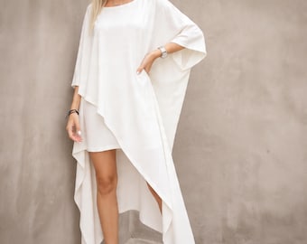 Abito caftano bianco asimmetrico, tunica ampia e fluida in stile boho da resort, outfit estivo minimalista e rilassato.