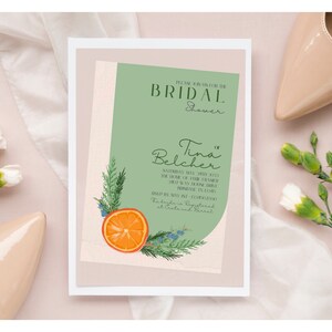 May include: A green and white bridal shower invitation with a floral design featuring an orange slice and greenery. The invitation reads "Please join us for the Bridal Shower for Tina Belcher, Saturday, May 28th, 2023 at the home of [Name] at [Address].  Gifts may be registered at Crate and Barrel."