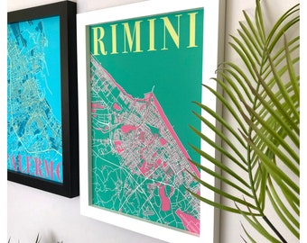 May include: A white framed print with a green background and a pink city map of Rimini, Italy. The city name is written in yellow letters at the top of the print.