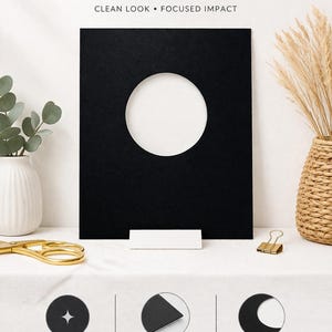 May include: A black porthole mat with a circular aperture, with the text "Porthole Mats." The mat is displayed with a white backing and text indicating premium quality, acid-free, and precision cut. Decorative elements include a vase, scissors, and a paper clip.