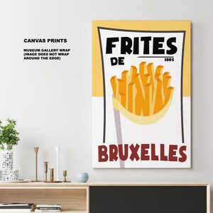 Puede incluir: Una impresi&oacute;n en lienzo amarillo y blanco con el texto "FRITES DE 1985 BRUXELLES" y un gr&aacute;fico de papas fritas en un cono de papel.