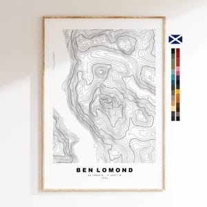 Può includere: Una stampa verticale incorniciata che presenta una mappa topografica in bianco e nero di Ben Lomond. La mappa mostra complesse linee di contorno, con il testo BEN LOMOND, le coordinate 56.19863 N, -4.63317 W e 974m stampati sotto.