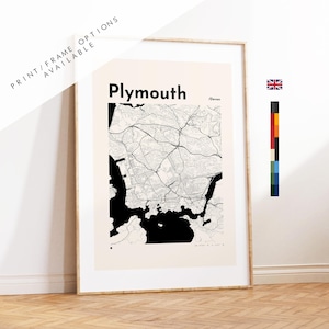 Puede incluir: Una lámina enmarcada con un mapa en blanco y negro de Plymouth, Devon. El mapa muestra intrincadas redes de carreteras y contornos costeros sobre un fondo de color crema claro. El texto Plymouth y /Devon está impreso en una fuente negra.