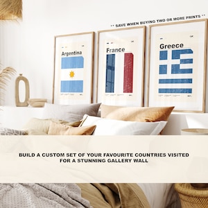 May include: Three framed prints of country flags, each with a different country name: Argentina, France, and Greece. The prints are displayed on a white wall above a bed with brown bedding and pillows. The text "SAVE WHEN BUYING TWO OR MORE PRINTS" is displayed above the prints. The text "BUILD A CUSTOM SET OF YOUR FAVORITE COUNTRIES VISITED FOR A STUNNING GALLERY WALL" is displayed below the prints.