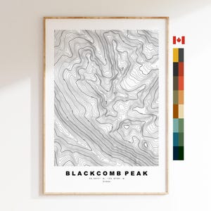 May include: A framed topographic map print of Blackcomb Peak featuring black contour lines on a white background. The text reads Blackcomb Peak, 50.0814 N, 122.8706 W, 2436m. A vertical color palette strip and a small Canadian flag are on the right.