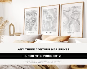 May include: Three framed vertical wall art prints featuring black and white topographic contour maps of Scafell Pike, Ben Nevis, and Snowdon. Each print displays detailed elevation lines and geographic coordinates on a white background.